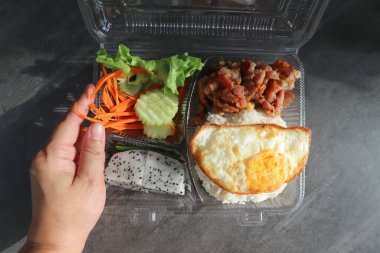 fried pork or stir fried pork with fruit and rice in the box