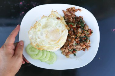 Kutsal fesleğenle kızartılmış domuz eti, pilav ve omlet.