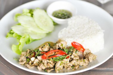 Üzerine kızarmış domuz eti ve fesleğen konmuş pirinç.