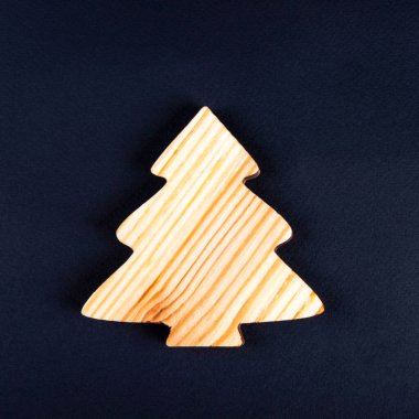 Koyu gri arka planda tahtadan bir köknar ağacı olarak yeni yıl kavramı.