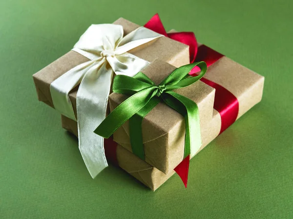 Tres regalos bellamente embalados en el fondo verde. —  Fotos de Stock