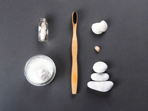 Un cepillo de dientes de bambú con el polvo de dientes decorando con conchas y piedras. — Foto de Stock
