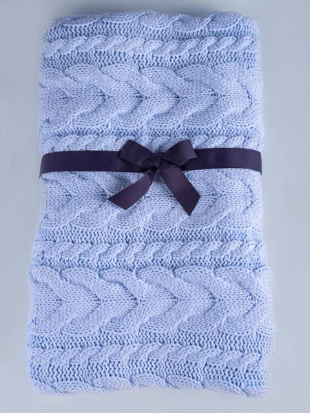 La funda de punto de lana en el color azul pálido con la cinta azul oscuro. —  Fotos de Stock