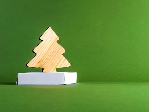 El concepto de cero desperdicio de año nuevo como un abeto de madera sobre el fondo verde. — Foto de Stock