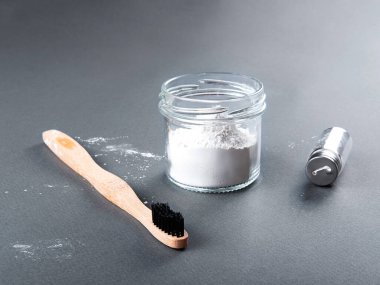 Üzerinde diş ipi ve diş pudrası olan bambu bir diş fırçası..