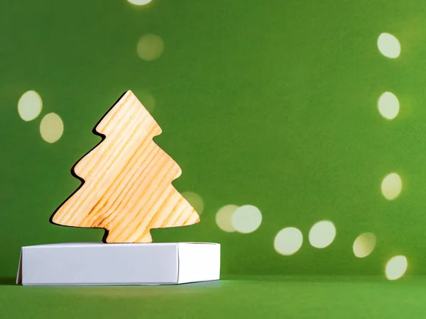 El concepto de cero desperdicio de año nuevo como un abeto de madera en el fondo verde con los destellos dorados. — Foto de Stock