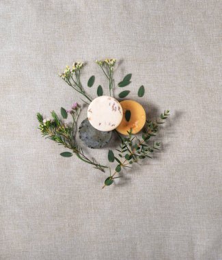 Pamuk arkaplanda çiçek dalları olan el yapımı üç sabun..