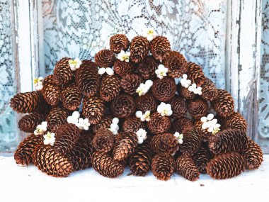 Güzel yeni yıl ya da Noel arkaplanı şirin kır evinin pencere kenarında beyaz böğürtlenli ideal çam kozalakları. Kış tatillerinin ve kutlamaların başlangıcı..