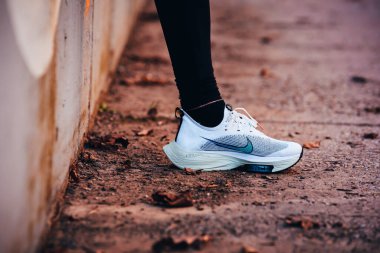 TOKYO, Japon, Mart 18. 2021: Nike koşu ayakkabıları ALPHAFLY NEXT%. Tartışmalı atletizm ayakkabıları yolda koşan profesyonel atletlerin bacaklarında. Tokyo Olimpiyatları için resmi beyaz ayakkabı 2020 maratonu