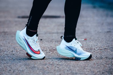TOKYO, Japon, Mart 18. 2021: Nike koşu ayakkabıları ALPHAFLY NEXT%. Tartışmalı atletizm ayakkabıları yolda koşan profesyonel atletlerin bacaklarında. Tokyo Olimpiyatları için resmi beyaz ayakkabı 2020 maratonu