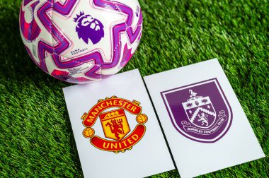 LONDON, UNITED KINGDOM, FEBRUARY 23, 2026: Manchester United, Burnley İngiliz Premier Ligi karşılaşması, takım logoları ve yeşil çimlerde futbol topu
