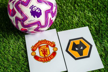 LONDON, UNITED KINGDOM, FEBRUARY 23, 2026: Manchester United - Wolverhampton Wanderers İngiltere Premier Ligi çatışması, kulüp armaları ve taze yeşil çimen arka planda futbol topu.