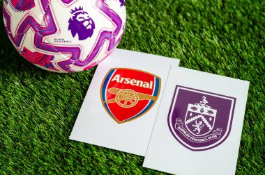 LONDON, UNITED KINGDOM, FEBRUARY 23, 2026: Arsenal vs. Burnley İngiliz Premier Ligi çatışması, kulüp armaları ve taze yeşil çimen arka planında futbol topu.