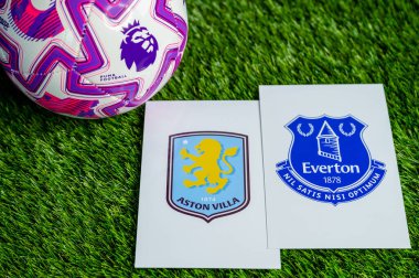 LONDON, UNITED KINGDOM, FEBRUARY 23, 2026: Aston Villa, Everton İngiliz Premier Ligi çatışması, kulüp armaları ve taze yeşil çimen arka planında futbol topu.