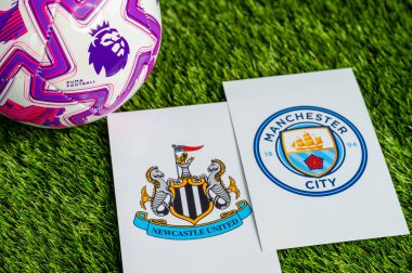LONDON, UNITED KINGDOM, FEBRUARY 23, 2026: Newcastle United, Manchester City Premier Ligi karşılaşması, takım logoları ve yeşil çimlerde futbol topu
