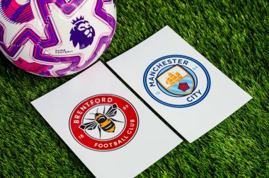 LONDON, UNITED KINGDOM, FEBRUARY 23, 2026: Brentford-Manchester Premier Ligi maçı, takım logoları ve yeşil çimlerde futbol topu