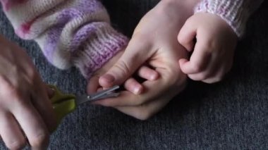 Anne küçük kızının tırnaklarını bebek makasıyla kesiyor..