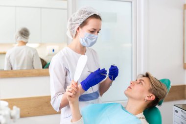 Dişçi danışmanlığındaki genç kadın. Diş kliniğinde kontrol ve diş tedavisi. Ağız temizliği ve tedavi.