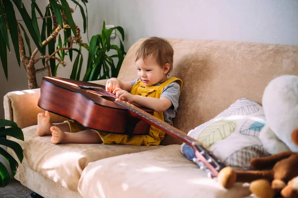 Garoto Bonito Toca Com Uma Grande Guitarra Acústica Casa Sofá — Fotografia de Stock