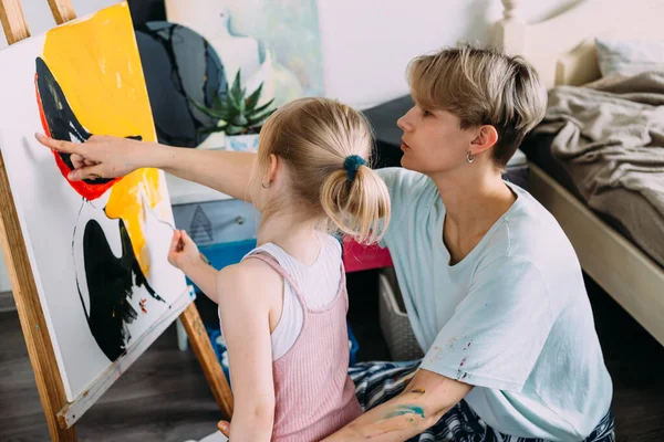 Güzel anne ressam ve çocuğu evde akrilik boyalarla resim yapıyorlar.. — Stok fotoğraf