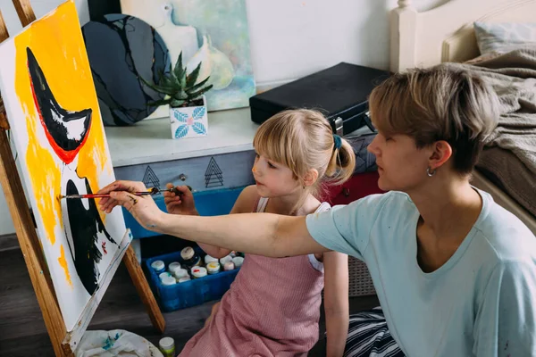 Güzel anne ressam ve çocuğu evde akrilik boyalarla resim yapıyorlar.. — Stok fotoğraf