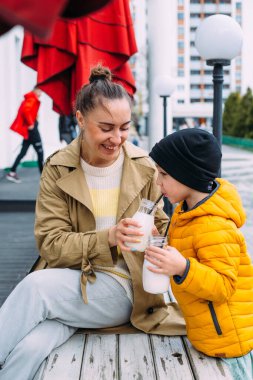 Genç anne ve oğlu dışarıda milkshake içip eğleniyorlar..