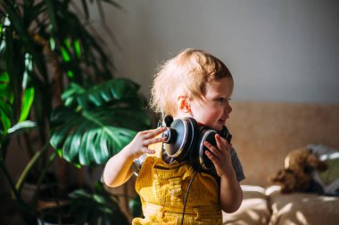 Komik küçük çocuk evde kulaklıkla eğleniyor, portre....