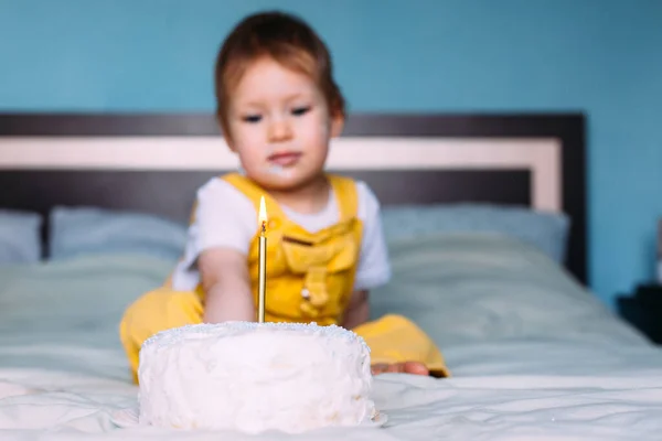작고 귀여운 아기가 케이크를 들고 집 침대에서 생일을 축하하고 있습니다 — 스톡 사진