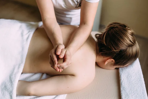 Massage therapeut doet massage op het vrouwelijk lichaam in de spa. — Stockfoto