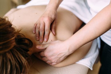 Masaj terapisti kaplıcadaki kadın vücuduna masaj yapıyor..