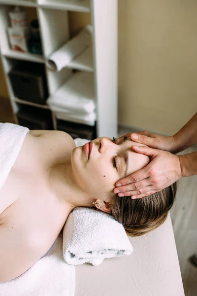 Masseur doet massage op een vrouw gezicht in de spa. — Stockfoto