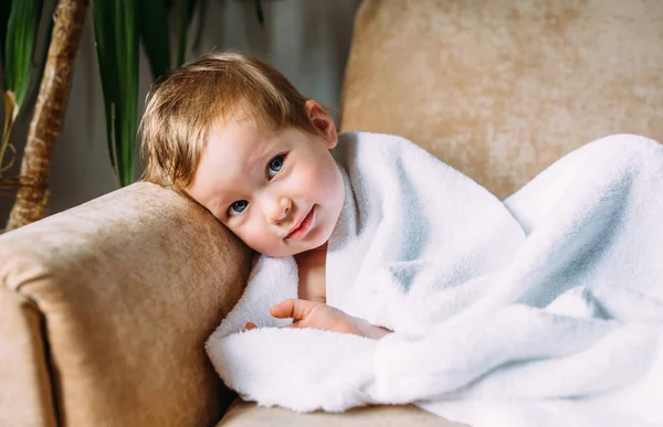 Симпатична дитина з блакитними очима, загорнута в білий рушник . — стокове фото