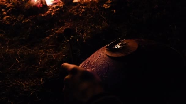 Hände eines Mannes, der mit Stöcken an einem Hänger spielt. Musik am Lagerfeuer. — Stockvideo