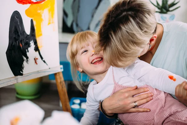 Güzel anne ressam ve çocuğu evde akrilik boyalarla resim yapıyorlar.. — Stok fotoğraf