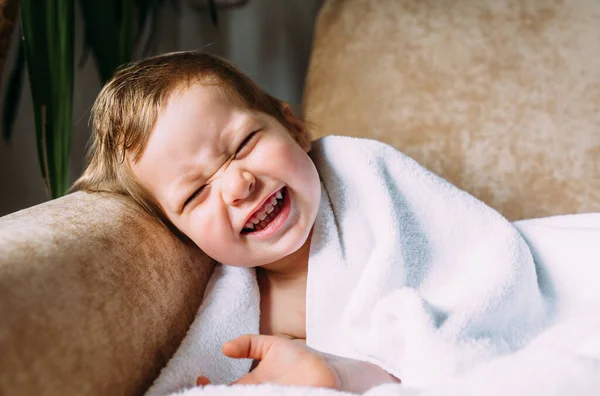 Criança bonito com olhos azuis envolto em uma toalha branca. — Fotografia de Stock