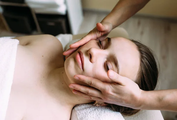 Masseur doet massage op een vrouw gezicht in de spa. — Stockfoto