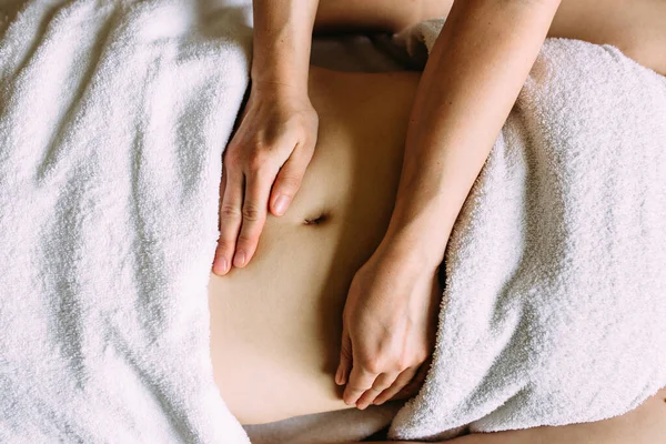 The masseur gives a massage to the female belly at the spa. — Stock Photo, Image