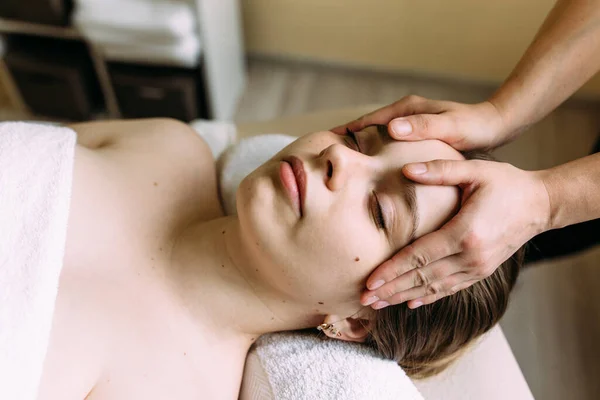 Masseur doet massage op een vrouw gezicht in de spa. — Stockfoto
