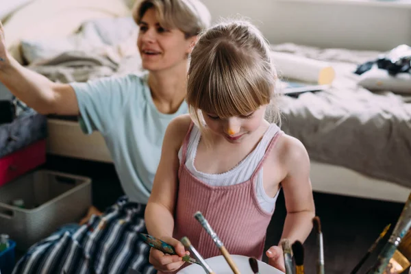 Güzel anne ressam ve çocuğu evde akrilik boyalarla resim yapıyorlar.. — Stok fotoğraf