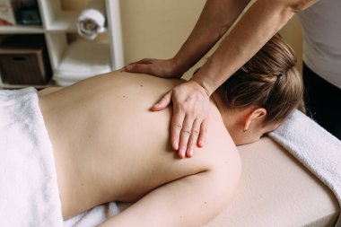 Masaj terapisti kaplıcadaki kadın vücuduna masaj yapıyor..