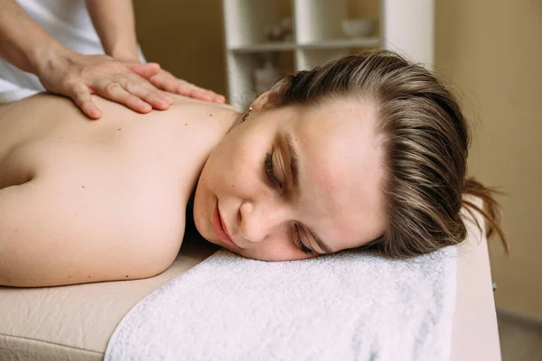 Massage therapeut doet massage op het vrouwelijk lichaam in de spa. — Stockfoto