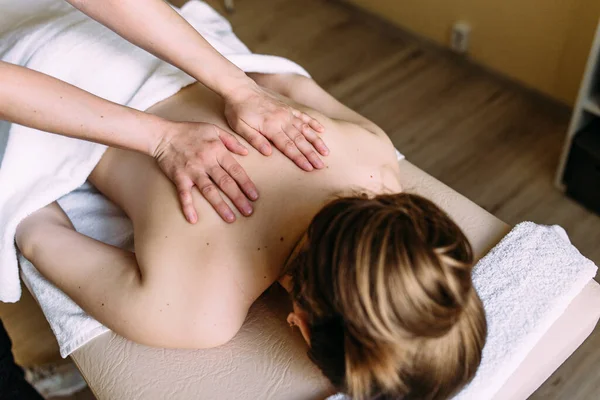 Massage therapeut doet massage op het vrouwelijk lichaam in de spa. — Stockfoto