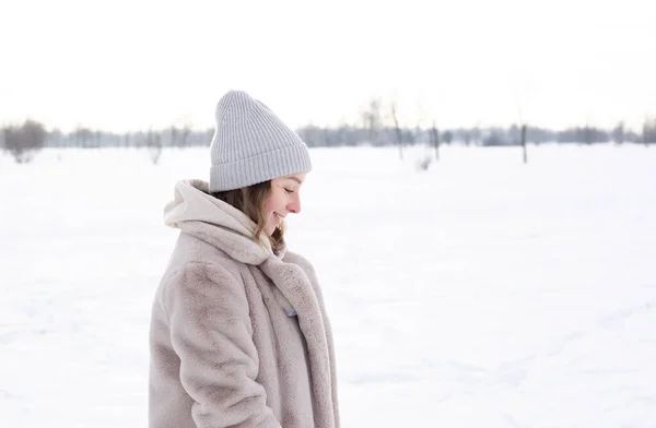 Young girl in beige clothes, fur coat made of artificial fur walks in winter — Stock Photo, Image