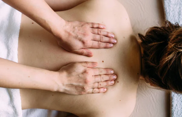 Massage therapeut doet massage op het vrouwelijk lichaam in de spa. — Stockfoto