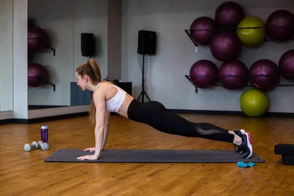 Young woman in sportswear doing stretching in indoor gym — Stock Photo, Image