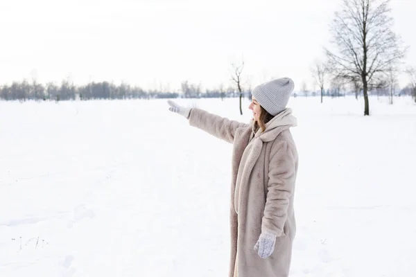 Junges Mädchen in beiger Kleidung, Pelzmantel aus Kunstpelz geht im Winter spazieren — Stockfoto