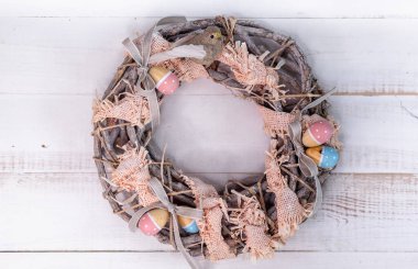 Dal ve kurdelelerden yapılmış el yapımı Paskalya çelengi. Sevimli kuş ve ahşap yumurtalar..