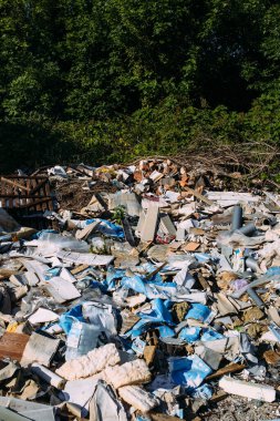 Ormanda çöp ve inşaat çöpleriyle dolu bir çöplük.