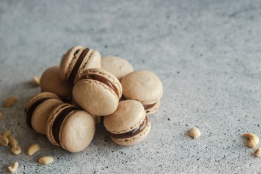 Kurabiyeler. Lezzetli Fransız tatlıları. Çikolata ganache 'li kurabiyeler. Masada kahverengi badem kurabiyeleri