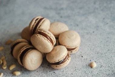 Kurabiyeler. Lezzetli Fransız tatlıları. Çikolata ganache 'li kurabiyeler. Masada kahverengi badem kurabiyeleri